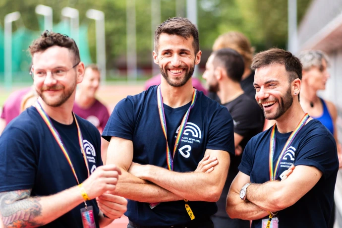 Three happy people standing and laughing