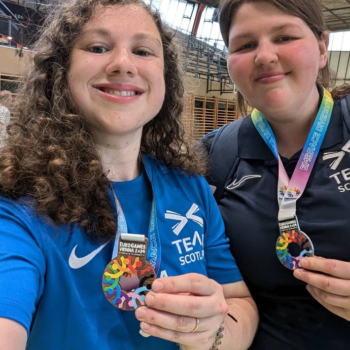 Article's interviewees holding colorful metals and smiling